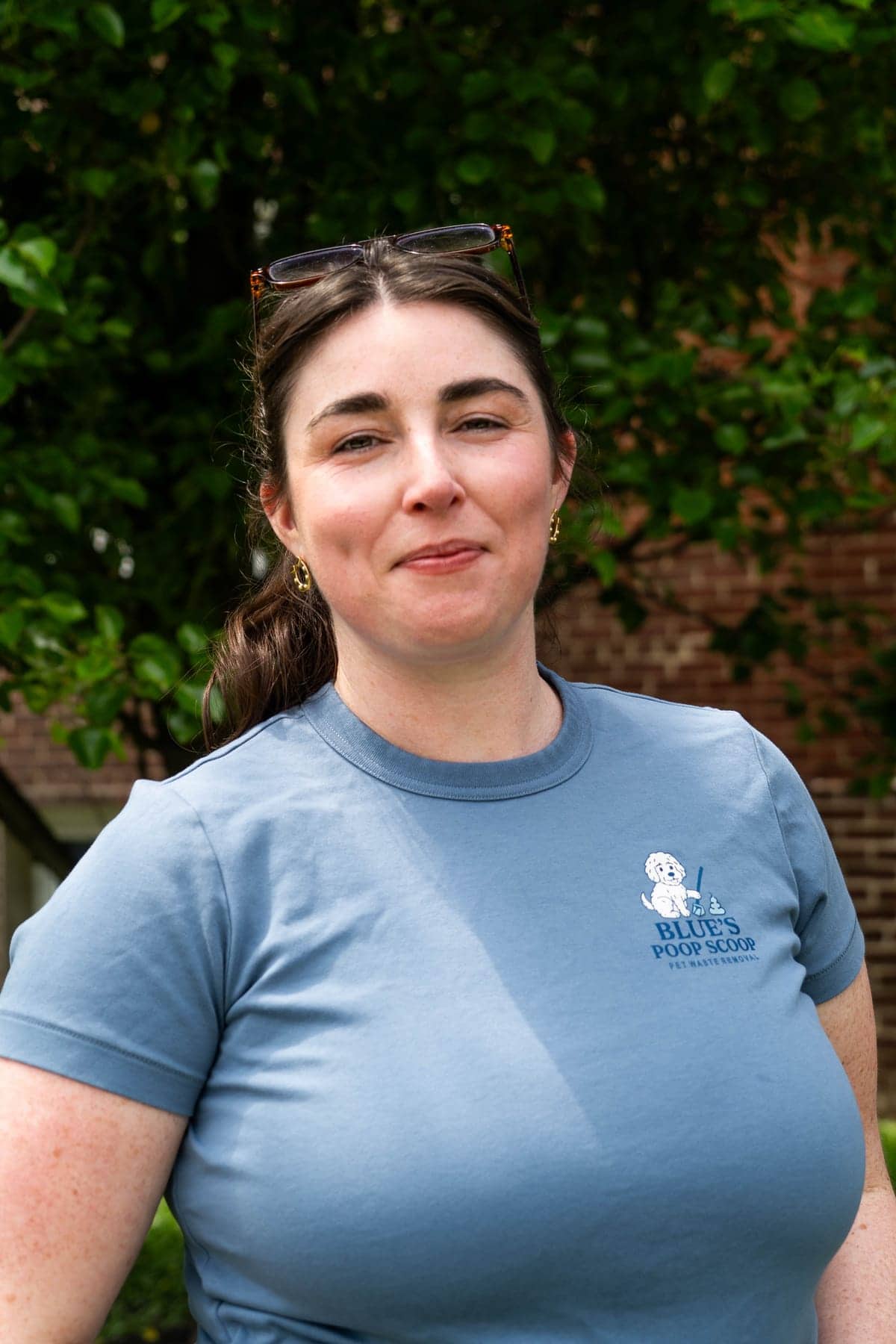 Sophie, in a Blue's Poop Scoop t-shirt, outside in front of a hedge